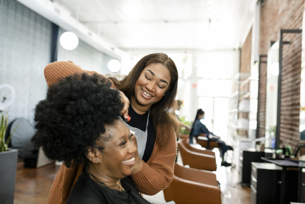 Hairstylist trimming a customer's hair at a beauty salon
